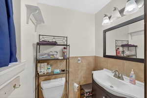 Half bath featuring vanity and tile walls