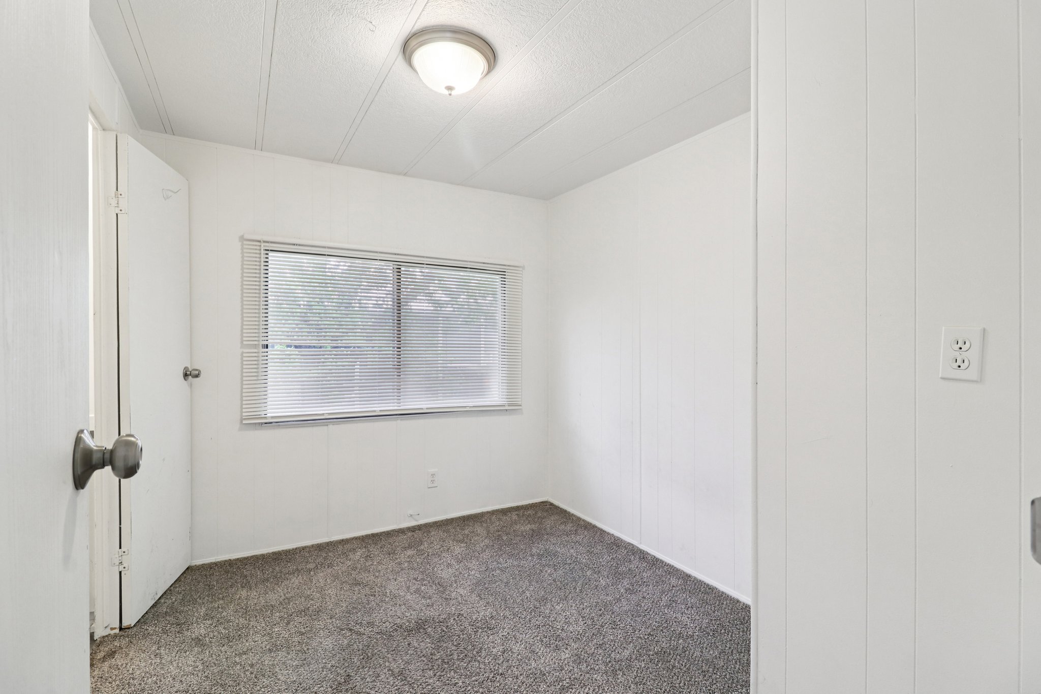 Unfurnished room featuring dark carpet and a textured ceiling