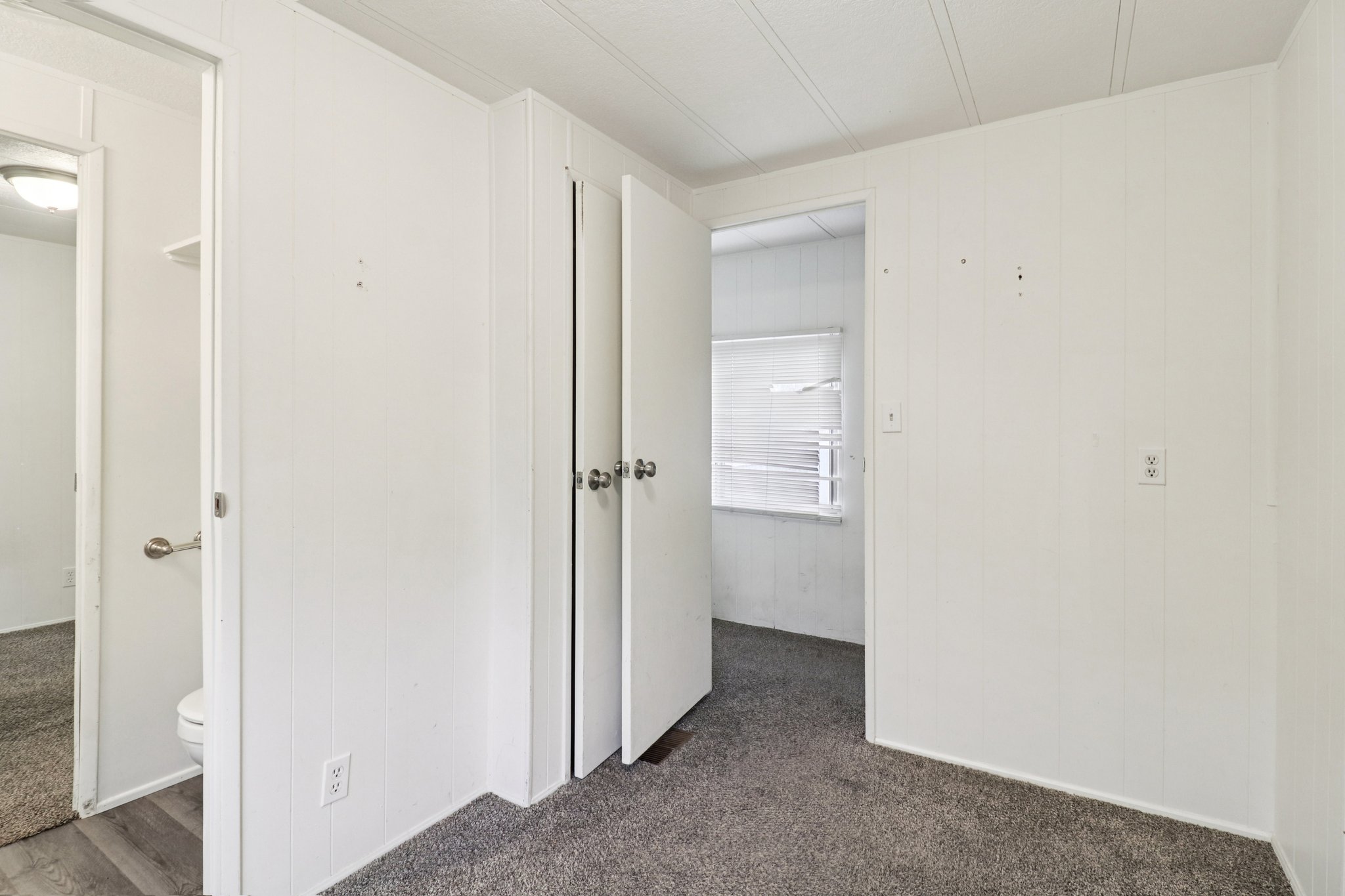 Hallway with dark carpet and wooden walls