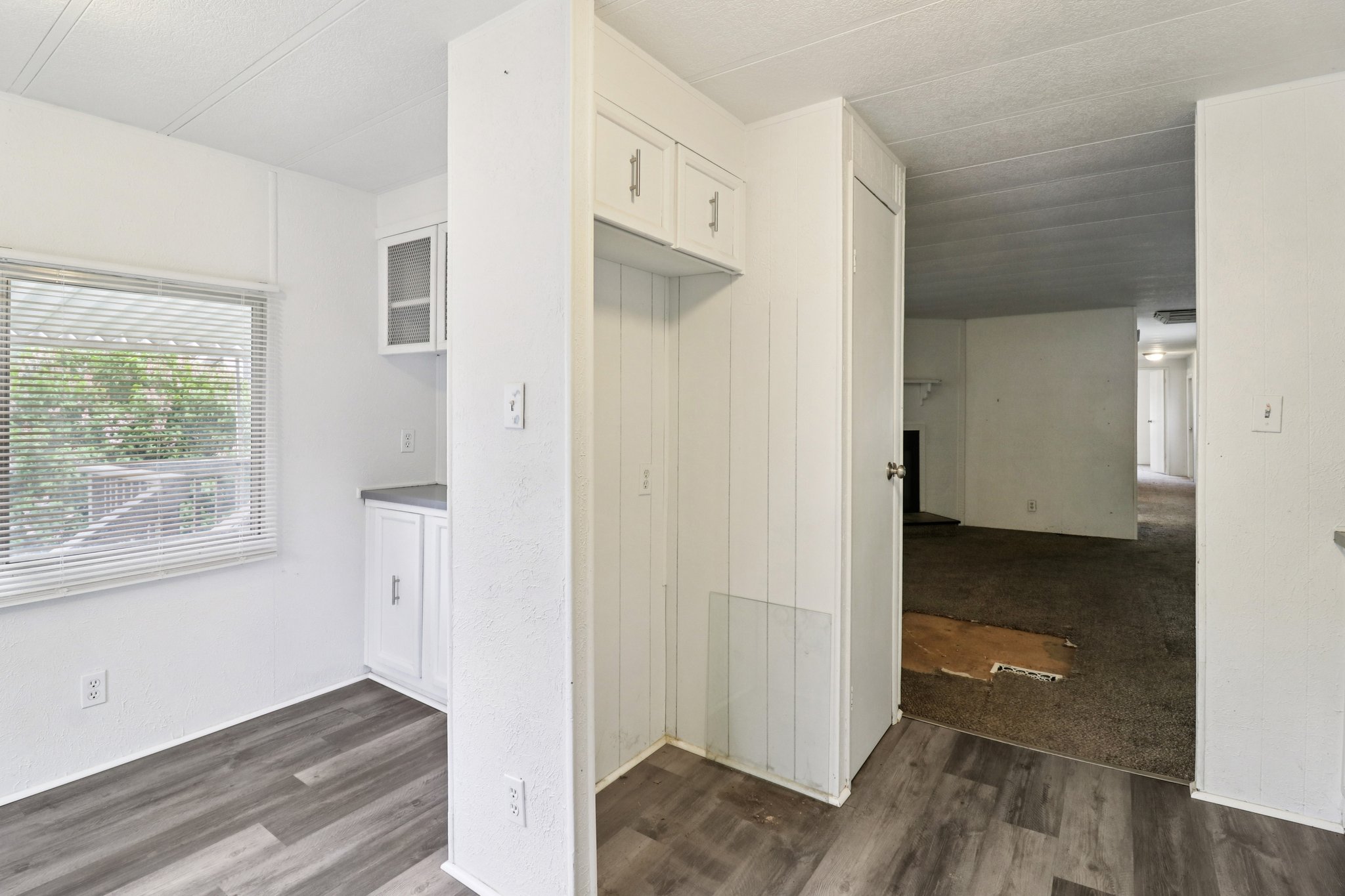 Kitchen with dark wood-style flooring and white cabinetry