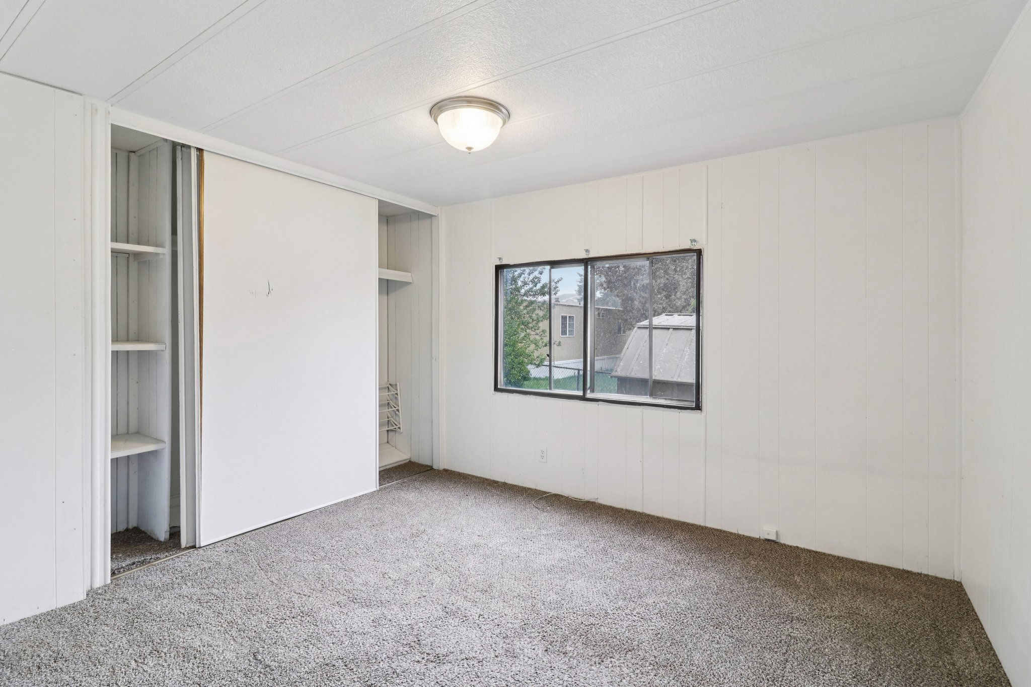 Unfurnished bedroom with carpet and wood walls
