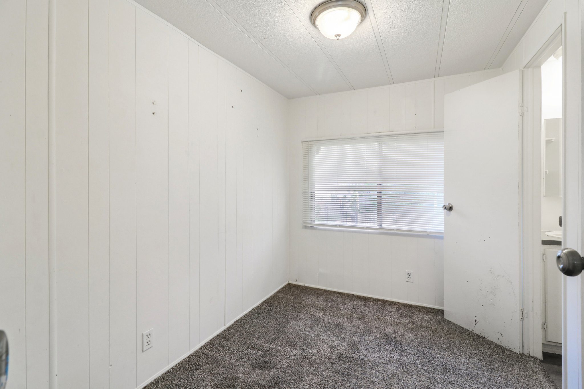Spare room with dark colored carpet and a textured ceiling