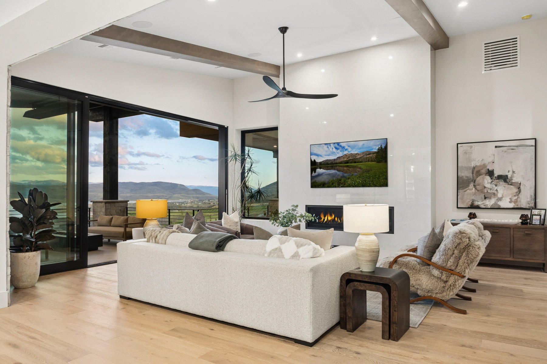 Living area featuring a fireplace, light wood finished floors, a ceiling fan, and recessed lighting