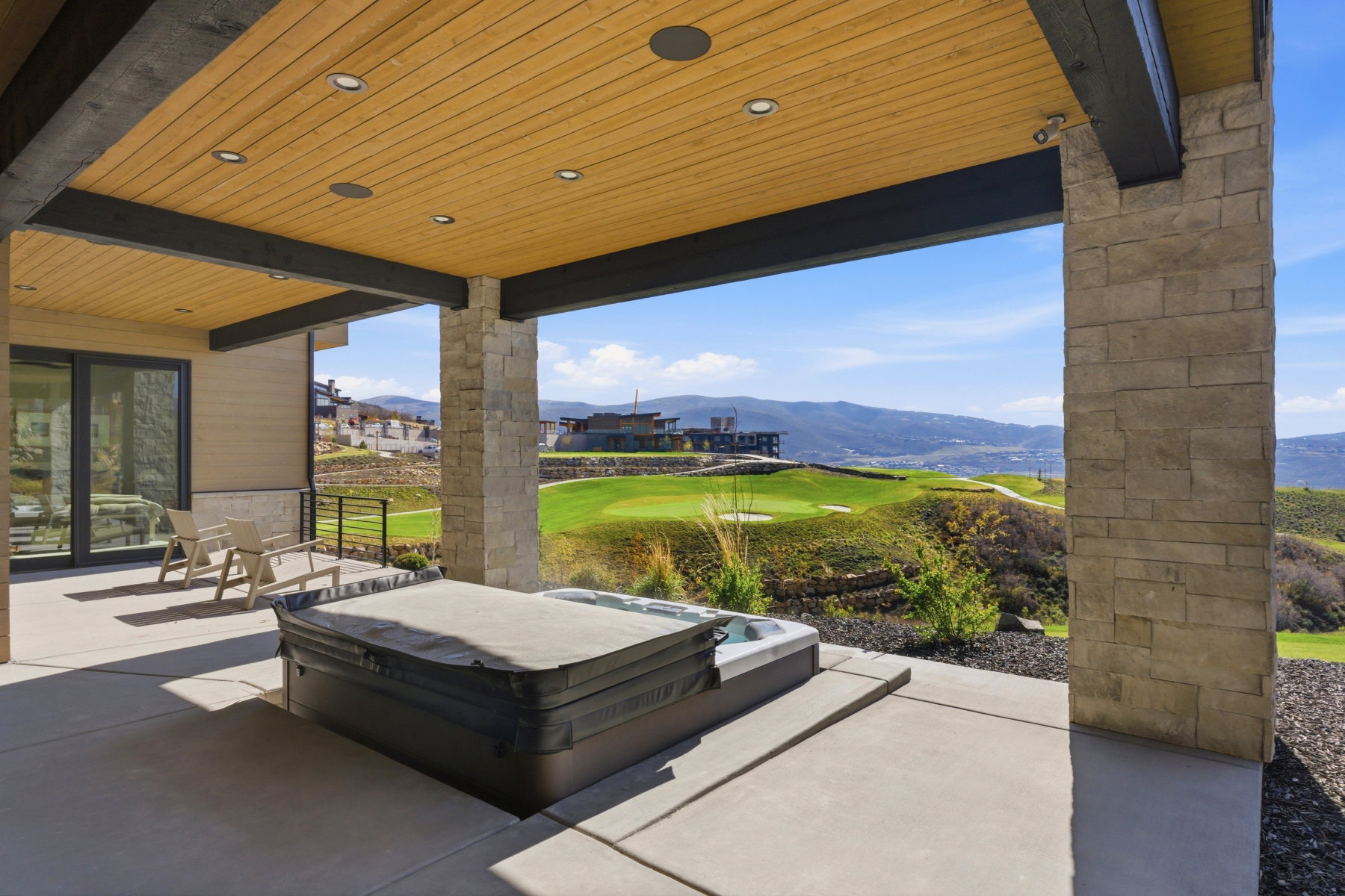 View of patio / terrace with a mountain view, a hot tub, and golf course view