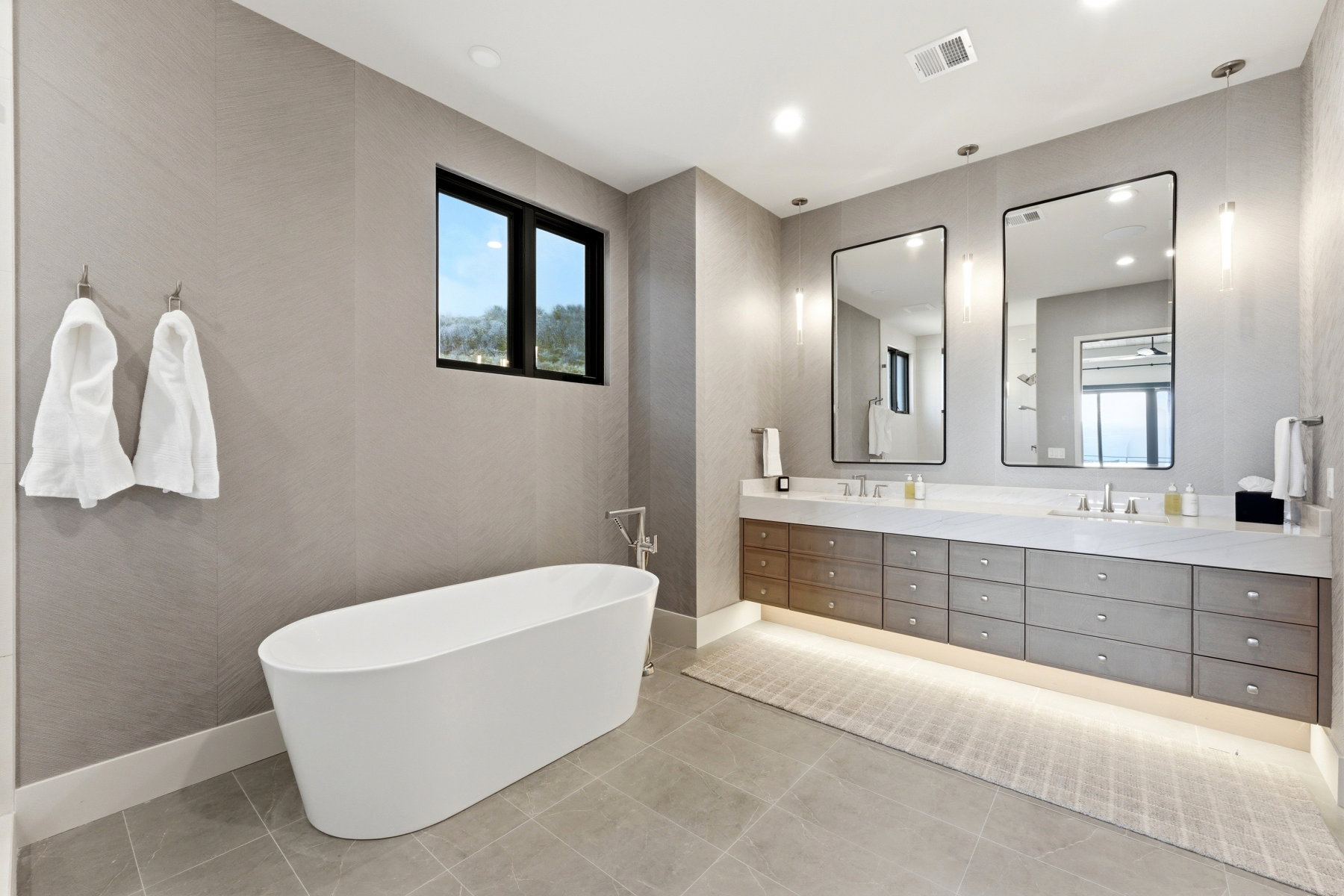 Bathroom with a freestanding tub, double vanity, and recessed lighting