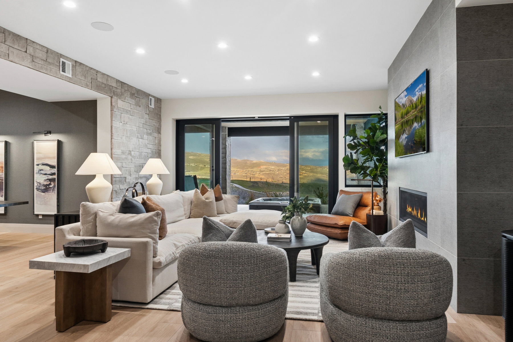 Living area with light wood finished floors, a large fireplace, and recessed lighting