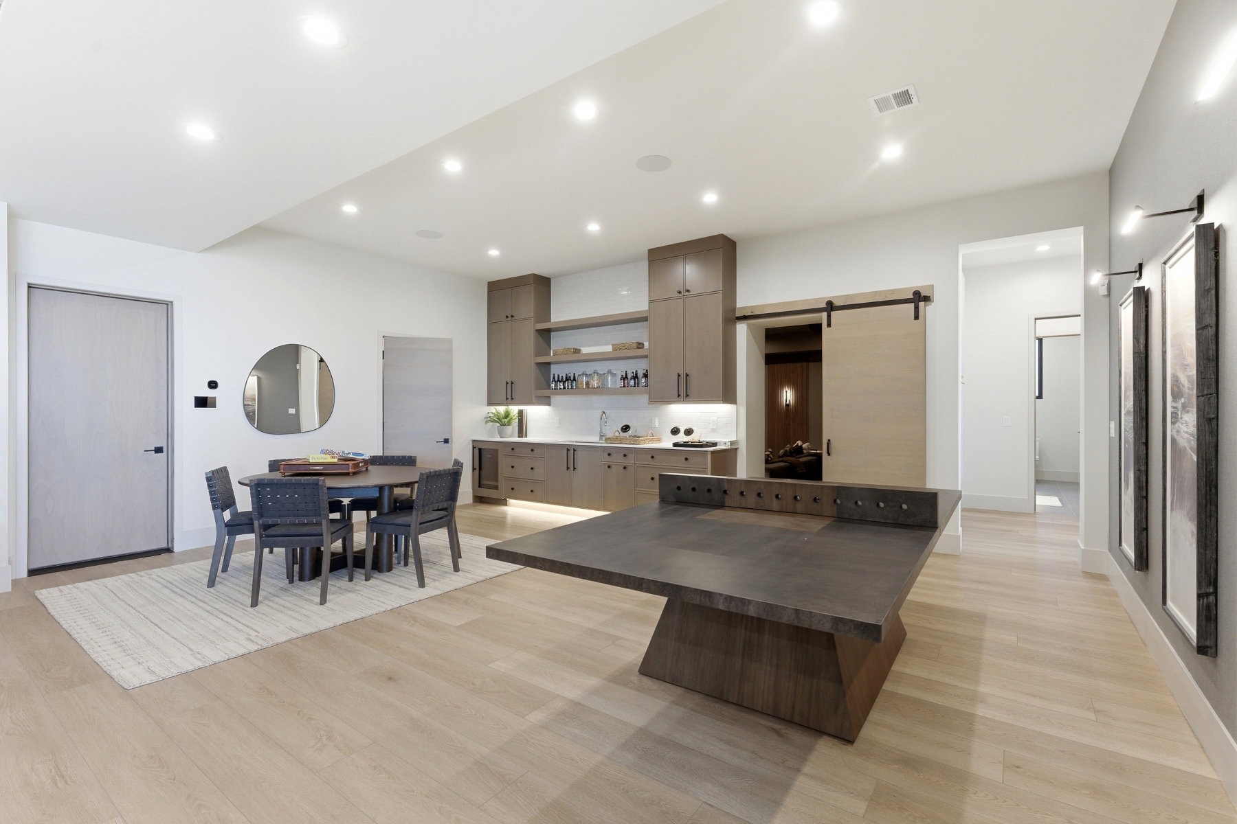 Kitchen with a barn door, light wood-type flooring, a center island, open shelves, and recessed lighting