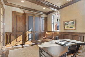 Home office with a wainscoted wall, wallpapered walls, beamed ceiling, a decorative wall, and hardwood / wood-style floors