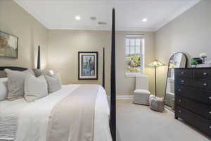 Carpeted bedroom with ornamental molding and recessed lighting