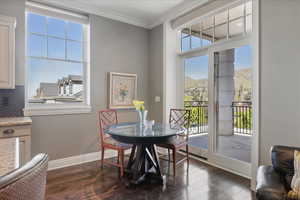 Dining area featuring dark wood-style flooring, crown molding, and a mountain view