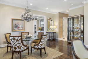 Dining area featuring ornamental molding, wood-type flooring, and suspended lighting