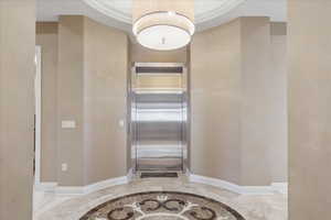 Hallway with elevator and light marble finish floors