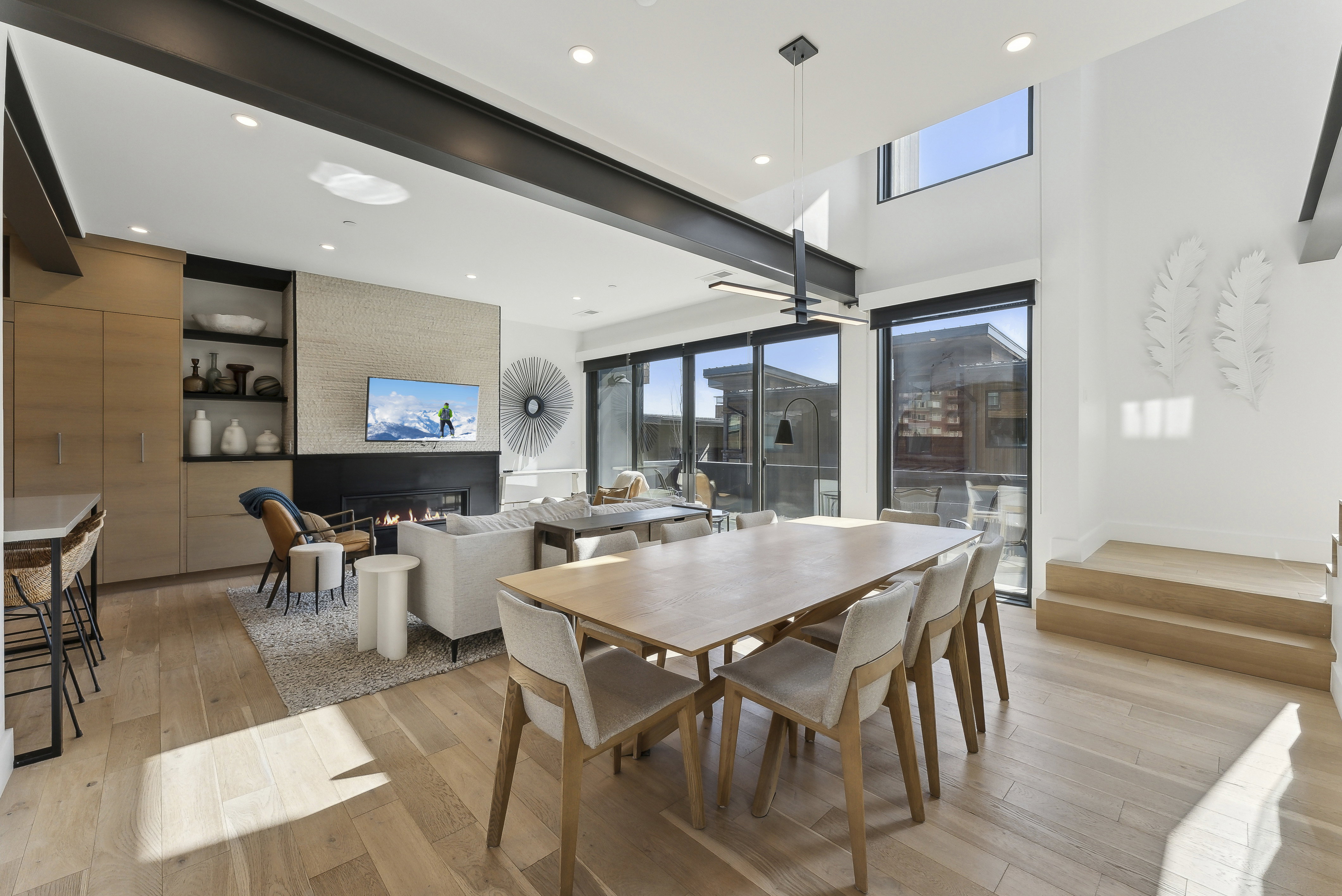 Dining space with light wood-type flooring, a ceiling fan, healthy amount of natural light, recessed lighting, and a high ceiling