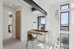 Home office with light carpet and baseboards