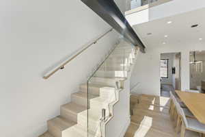 Staircase featuring wood finished floors and recessed lighting