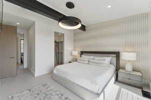 Bedroom with recessed lighting, a walk in closet, an accent wall, and wallpapered walls