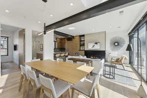 Dining space featuring light wood-style floors, a large fireplace, and recessed lighting