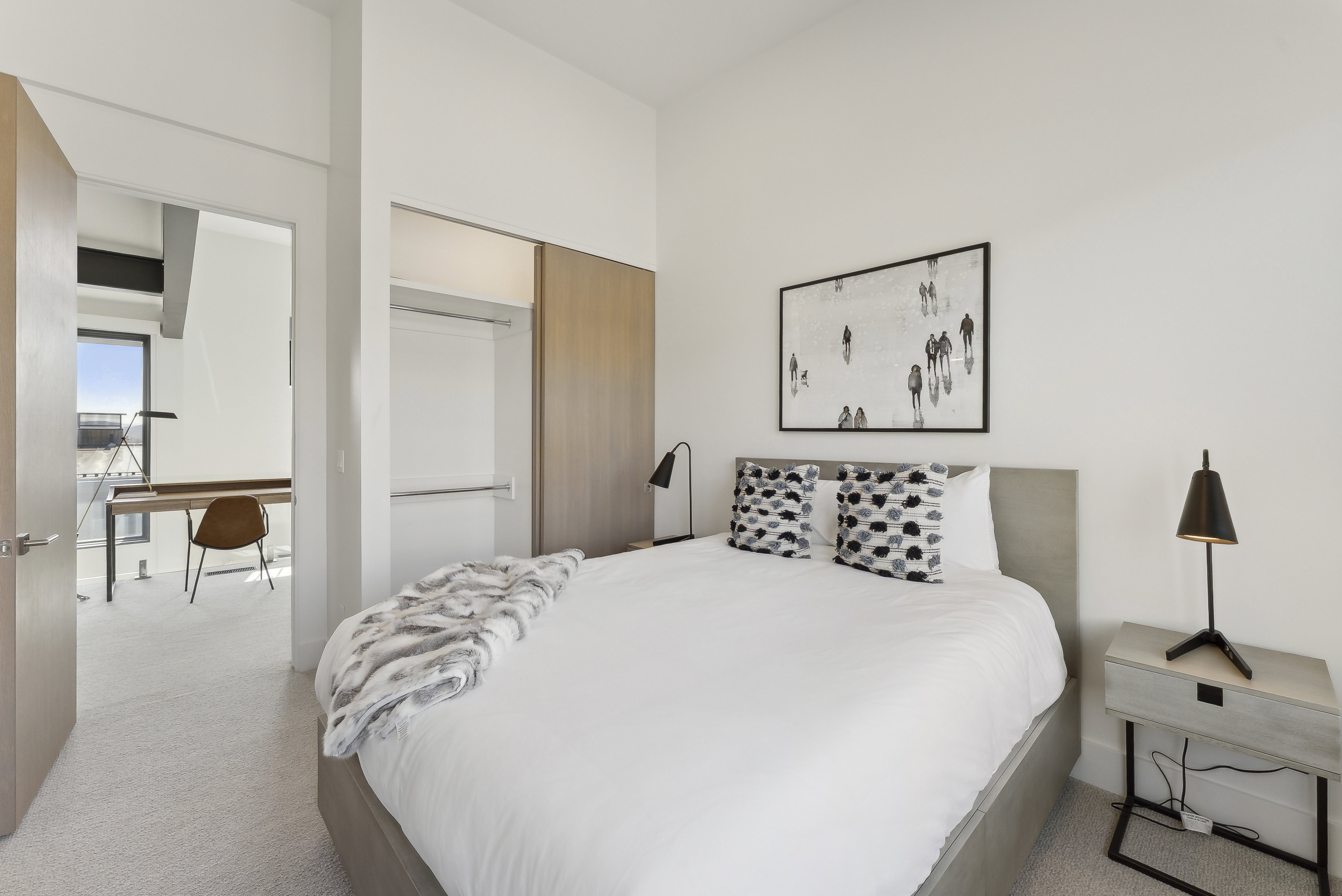 Bedroom with a desk, light carpet, and a closet