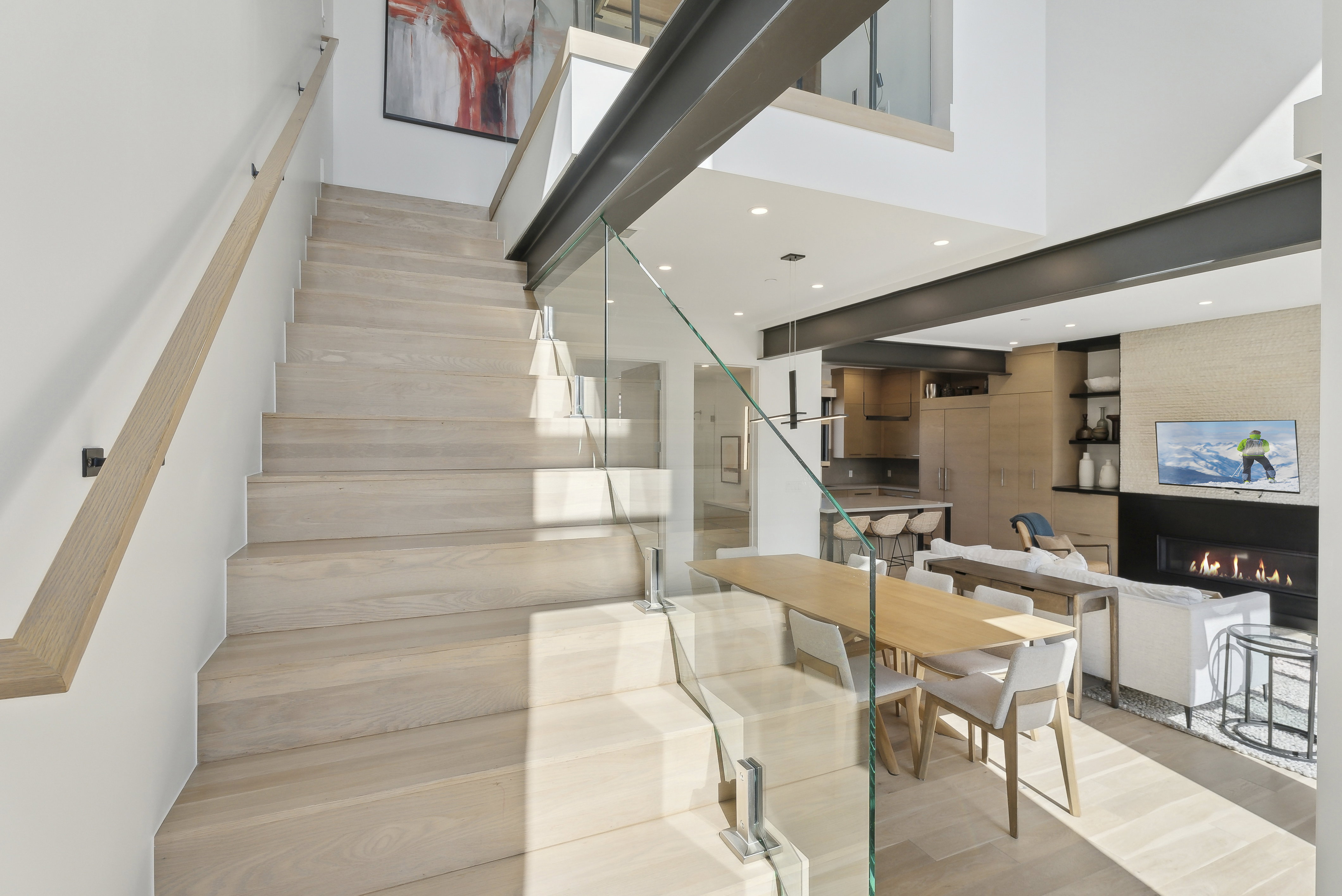 Stairs with a fireplace, recessed lighting, wood finished floors, and a high ceiling