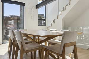 Dining area with light wood finished floors and stairway