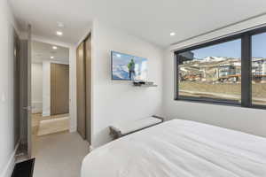 Bedroom with a closet, light colored carpet, and recessed lighting
