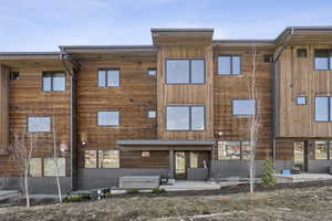 Back of house with a patio and a hot tub
