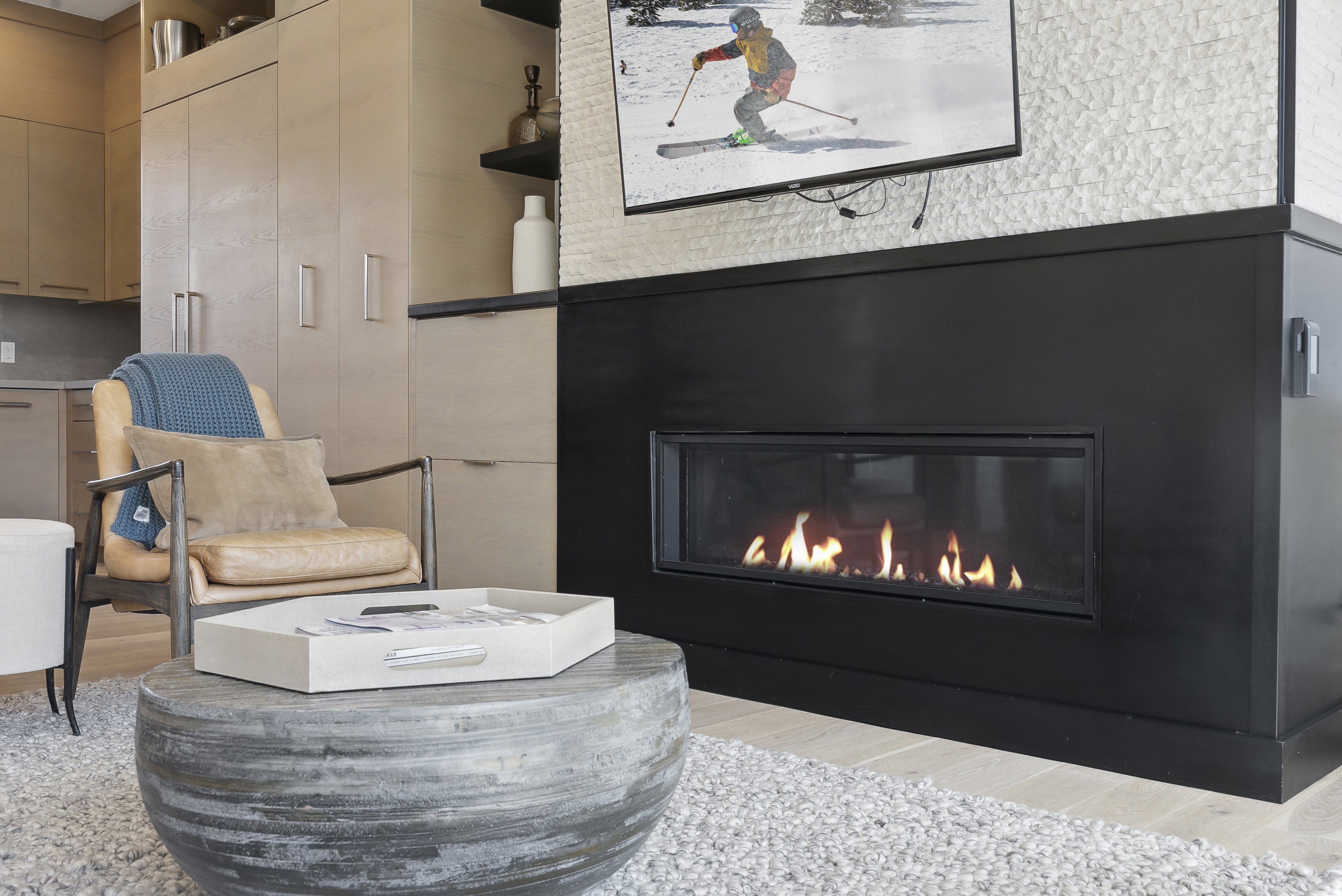 Sitting room featuring a glass covered fireplace and light wood finished floors