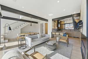 Living room with light wood finished floors and recessed lighting