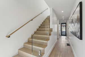 Stairway with hardwood / wood-style floors and recessed lighting