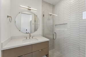 Full bath with a shower stall and vanity
