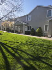 Traditional-style house with stucco siding and a front yard