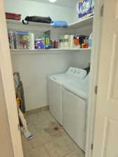Laundry area featuring brand new washer and clothes dryer included and light tile patterned floors