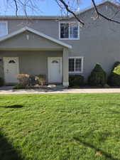 Traditional-style house with stucco siding and a front lawn