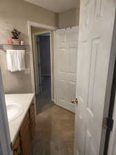 Bathroom featuring vanity and dark tile patterned floors