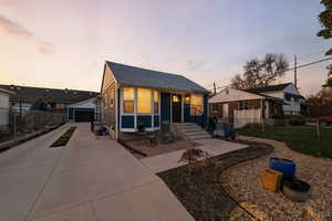 Side of house at dusk with 2-car garage and lots of extra parking