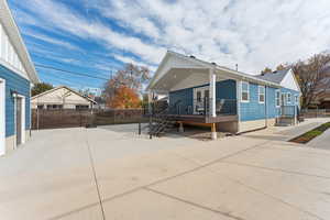Back of property featuring covered porch, ADU entrance, fenced yard, and lots of parking