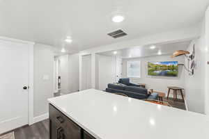 Basement ADU great room with LVP flooring, recessed lighting, and a textured ceiling