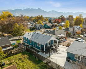Aerial view of back of home, yard, and mountains