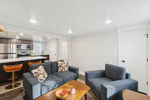 Basement ADU great room with LVP flooring, recessed lighting, and a textured ceiling