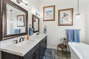Primary ensuite featuring double vanity, a soaking tub, and separate shower