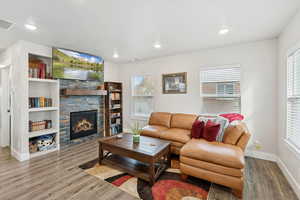 Living area with a stone fireplace, LVP floors, and recessed lighting