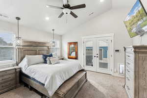 Primary Bedroom with french doors to back patio, light colored carpet, vaulted ceiling, and ceiling fan