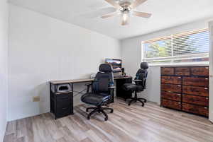 Office space with light wood-type flooring and ceiling fan