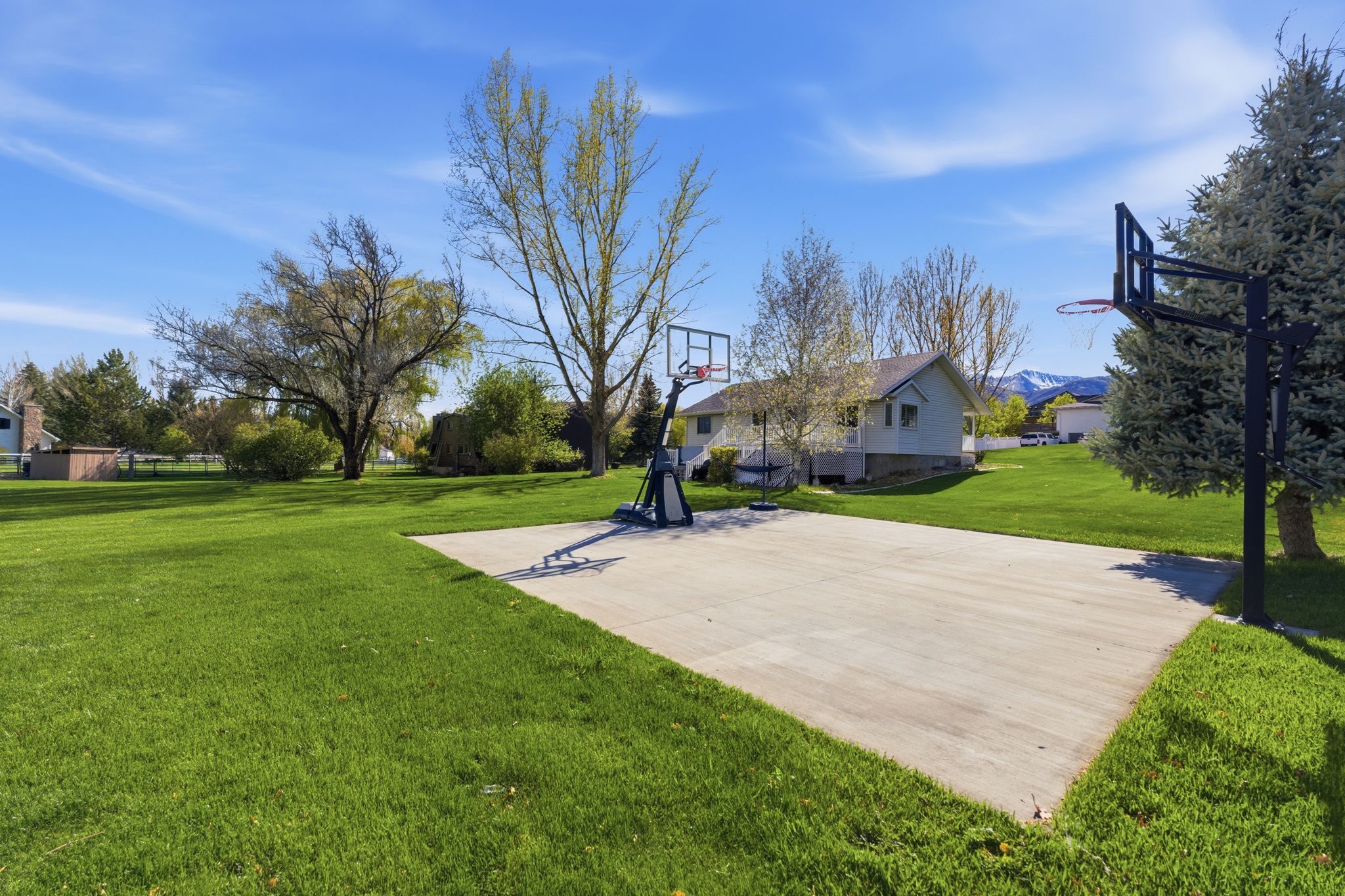 View of basketball court featuring a yard and basketball court