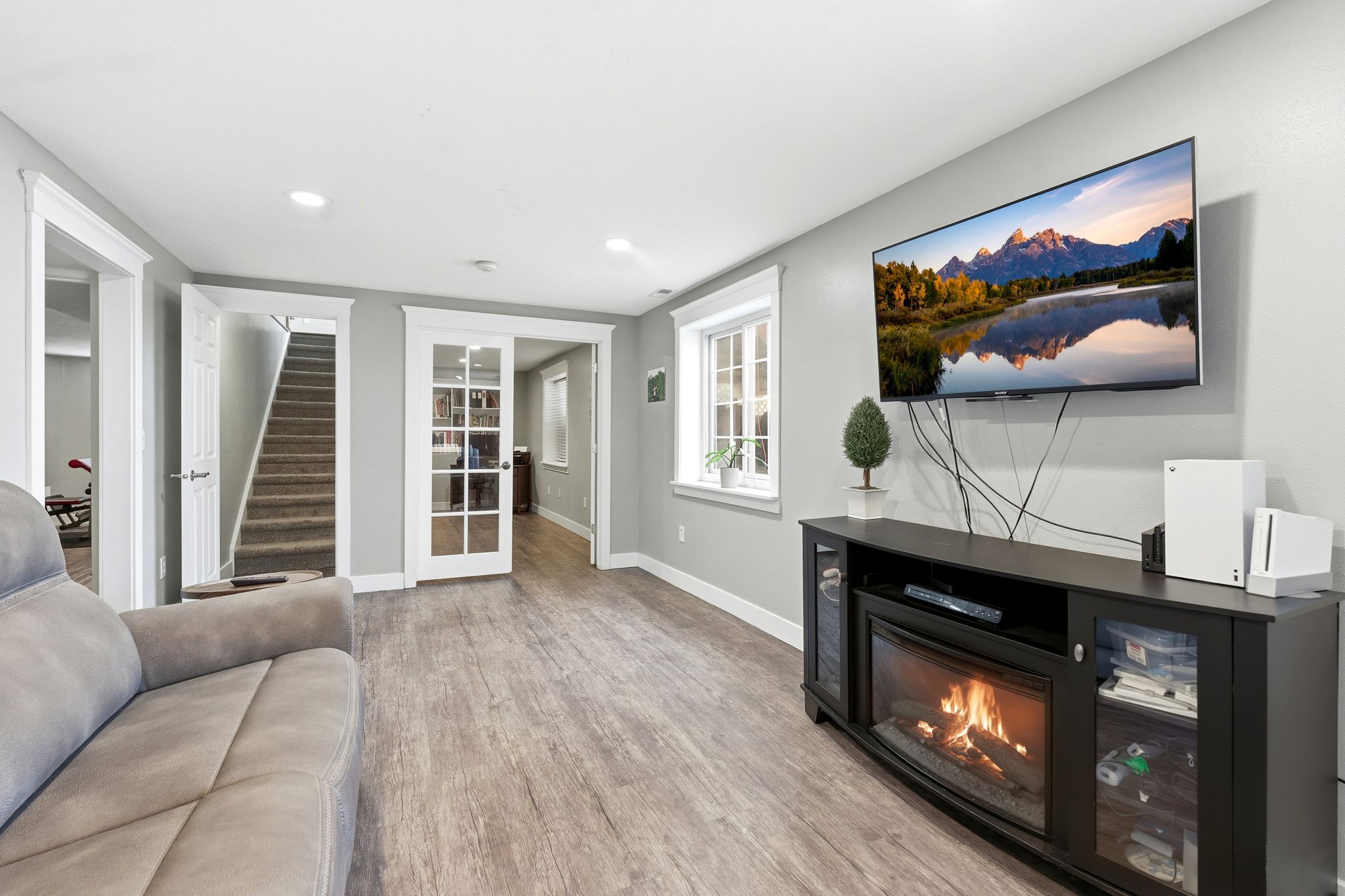 Living area featuring light wood finished floors, a glass covered fireplace, and recessed lighting