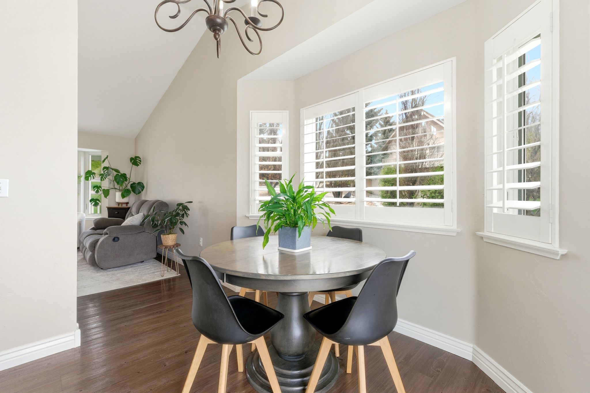 Dining space with dark wood finished floors, suspended lighting, and vaulted ceiling
