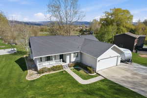 Ranch-style house featuring roof with shingles, a porch, an attached garage, and driveway