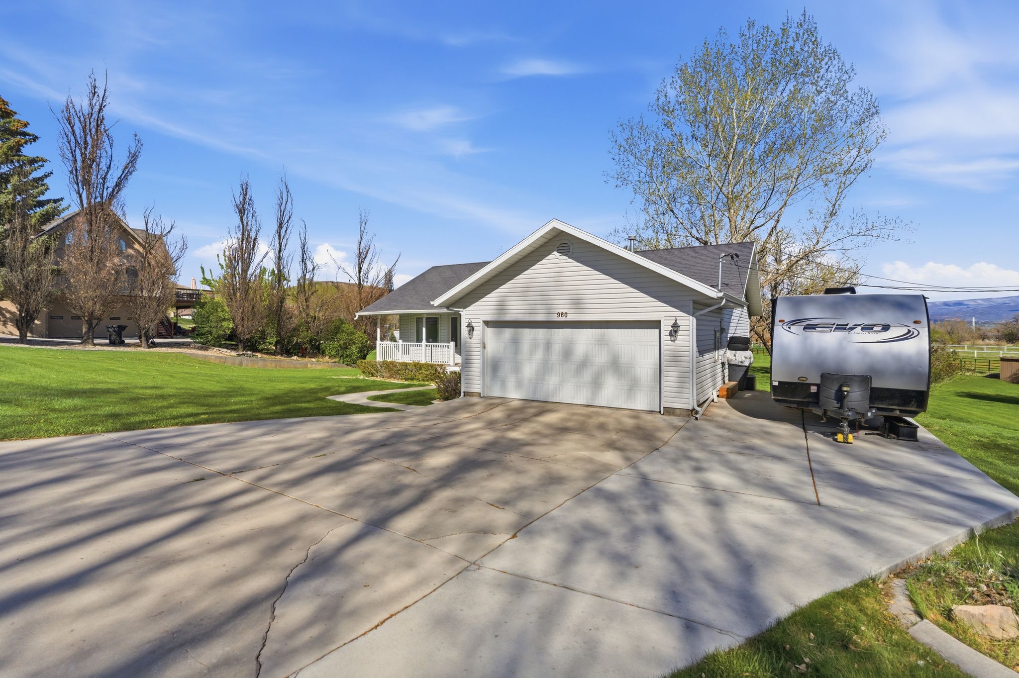 View of side of property with a lawn, an attached garage, and concrete driveway