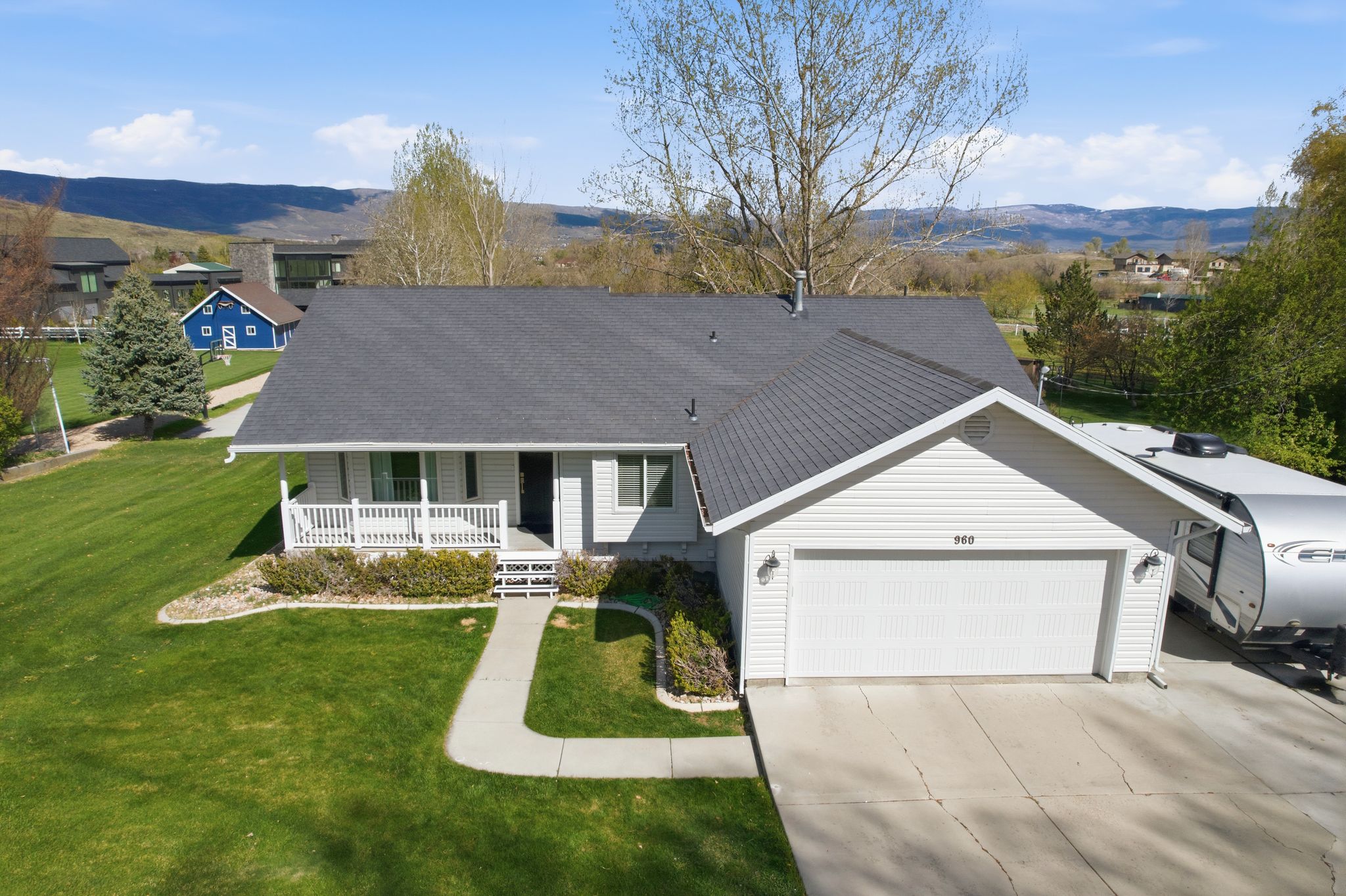 Single story home with a porch, a mountain view, roof with shingles, a garage, and driveway
