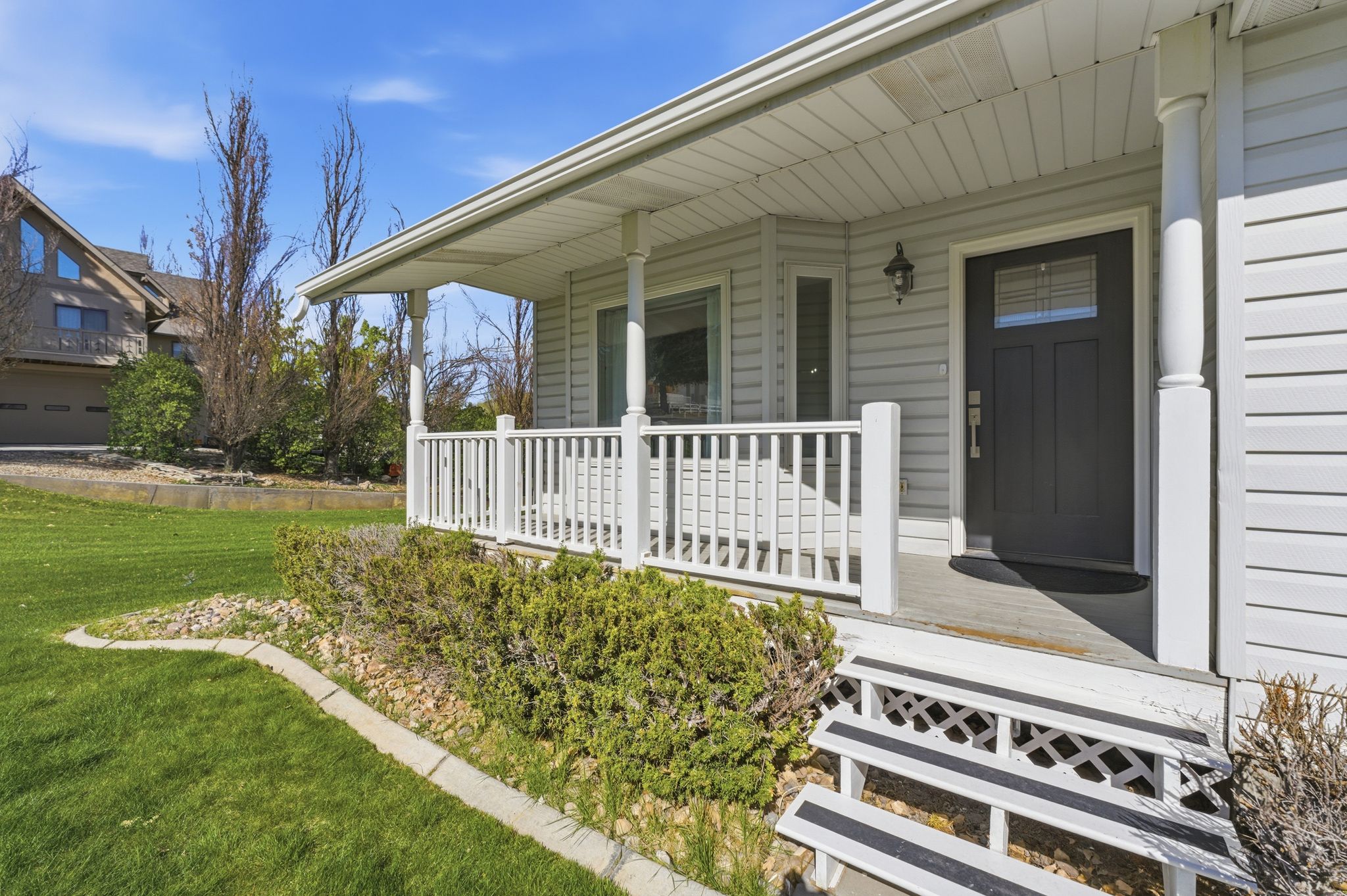 View of exterior entry with a porch and a yard